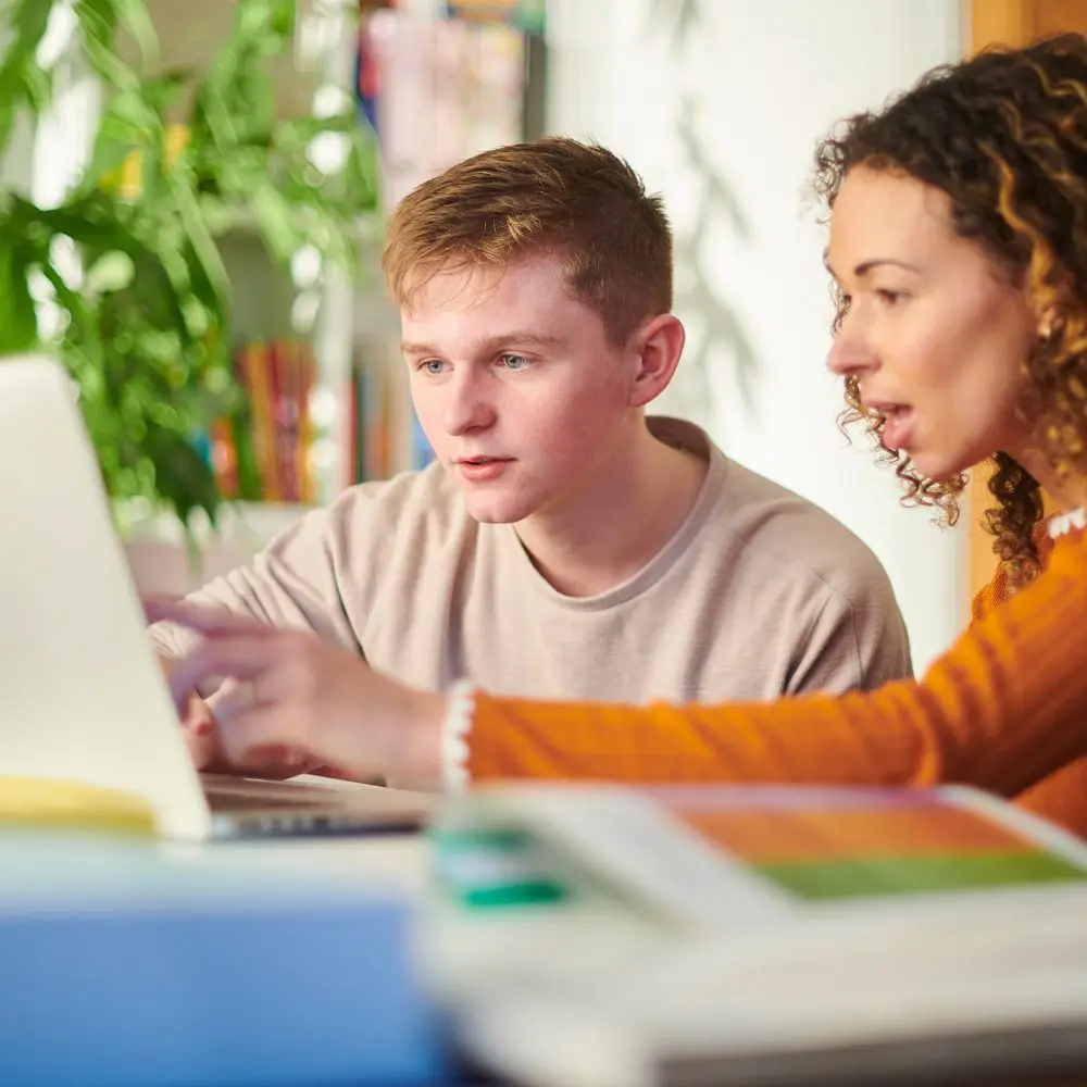 tutor and student both looking at a laptop during a tutoring session